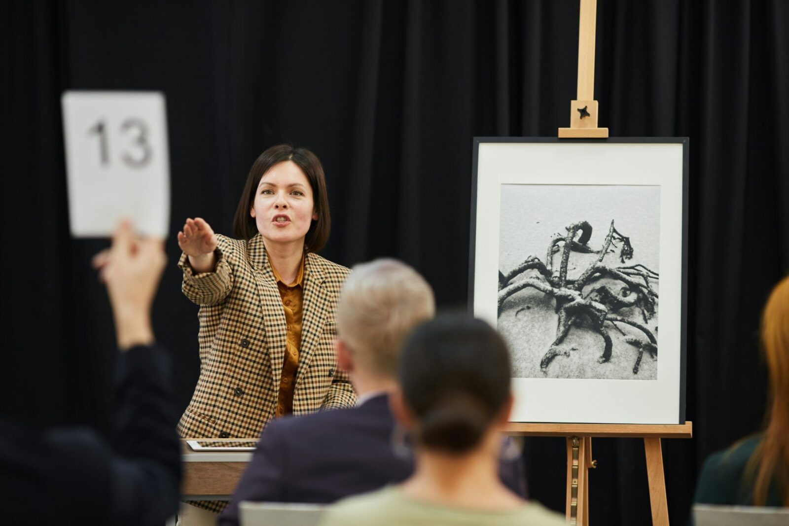 An auctioneer taking a bid on art in a saleroom