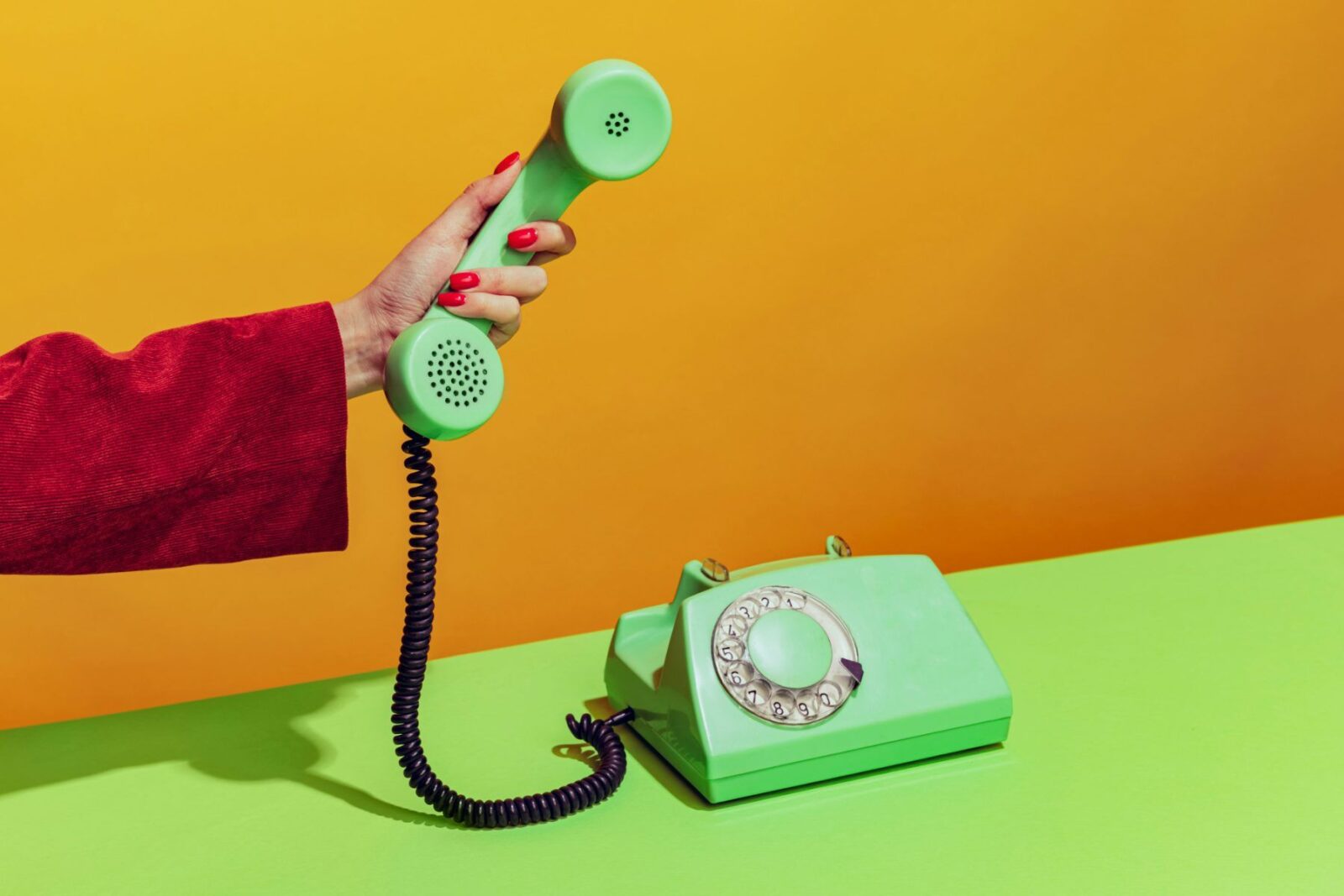 A hand holding out a phone: crypto recovery scams often start with a call