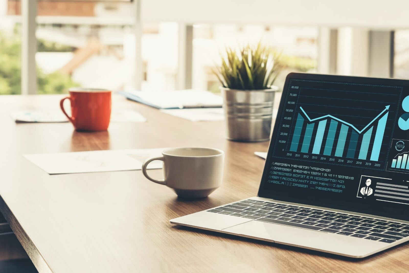 A laptop showing investment charts, comparing funds vs ETFs