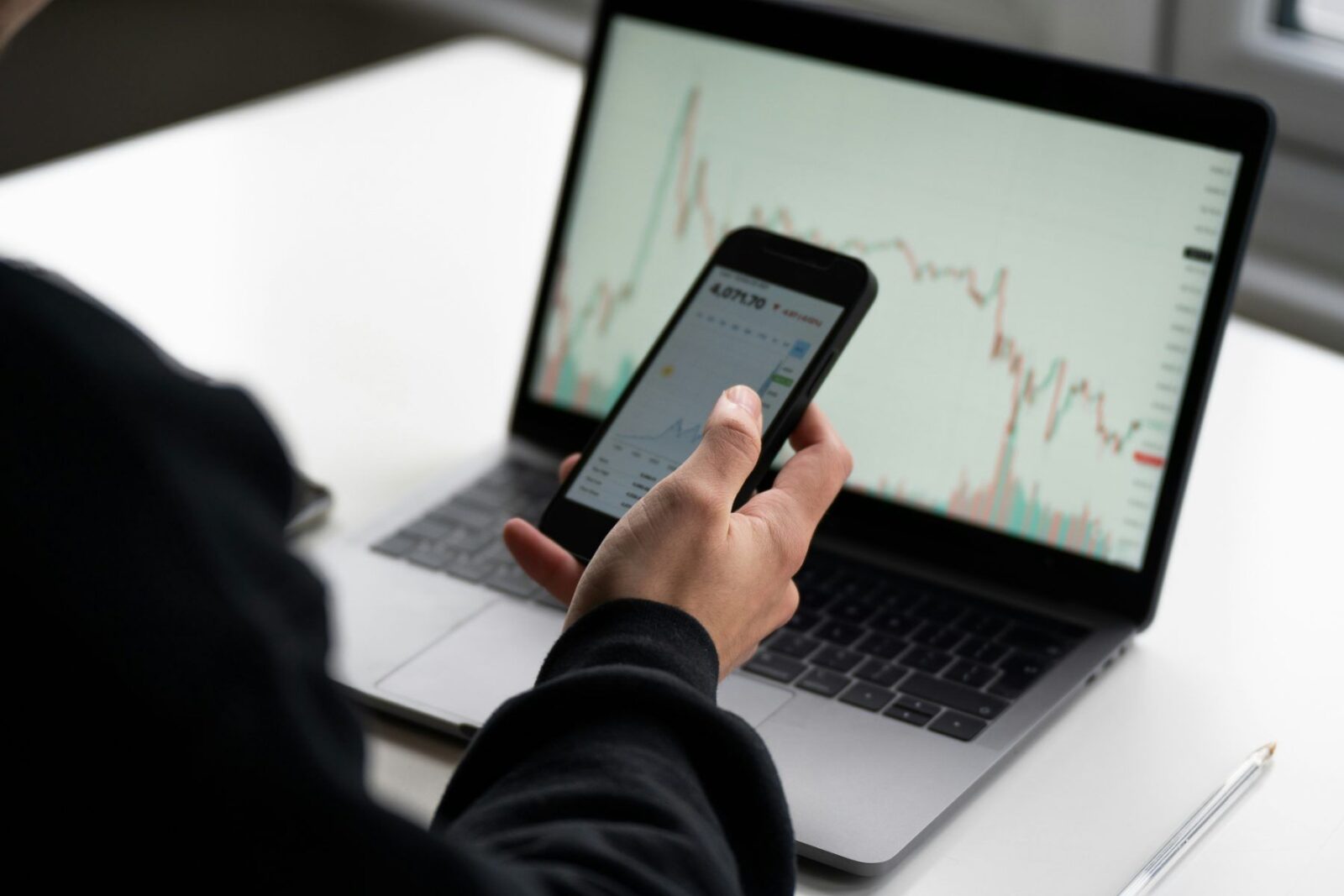 A person checking share prices on a phone, learning to invest in shares