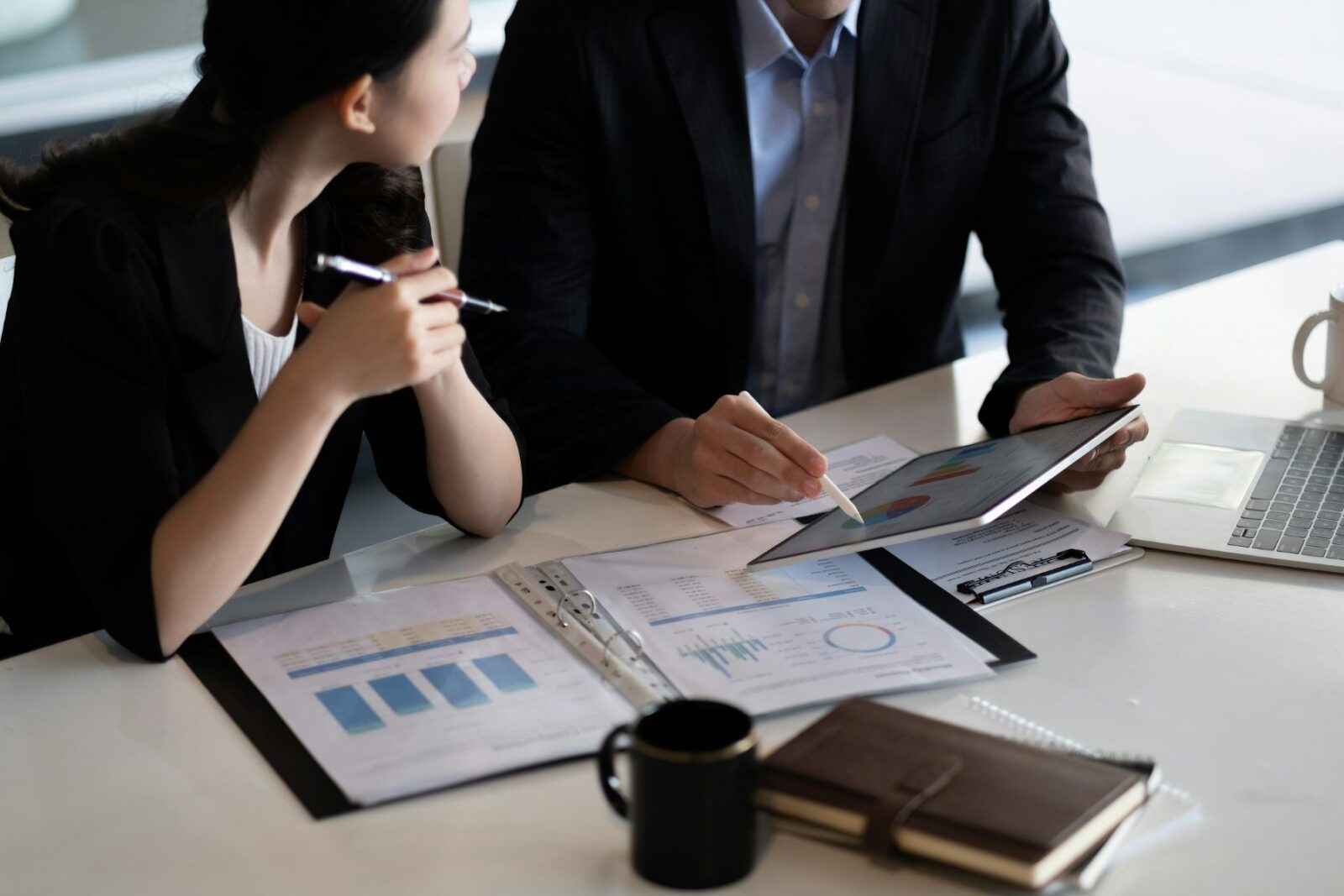 Two people comparing documents, weighing a VCT against SEIS and EIS